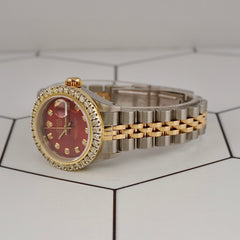 Side angle of Rolex Ladies Datejust 26mm with red dial and diamond bezel, showcasing two-tone 18k yellow gold and steel bracelet links.