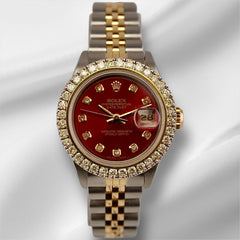 Rolex Ladies Datejust 26mm watch with red dial, 2ct diamond bezel, and two-tone 18k yellow gold and steel Jubilee bracelet on white satin background.